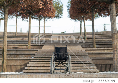 Wheelchair by the stairs without people outdoors.  88889149