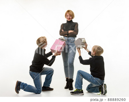 Children give a gift to mom while kneeling Children give a gift to mom while kneeling 88889260