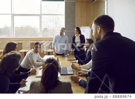 Group of business people in big office have meeting and discussing company stats and sheets. 88889674