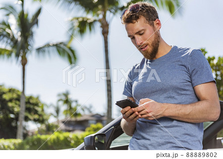 Car phone man driver using smartphone app for carsharing or travel vacation rental on new sports convertible. Summer holiday driving accident problem road trip assistance 88889802