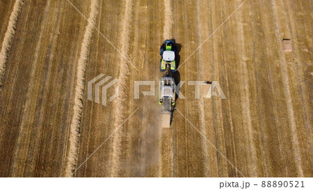 Hay bale tractor. Tractor harvesting hay into bales in field on sunny day. Hay bale tractor. Tractor harvesting hay into bales in field on sunny day. 88890521