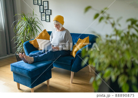 Mature beautiful blonde haired woman using laptop computer indoors. Mature beautiful blonde haired woman using laptop computer indoors. 88890875
