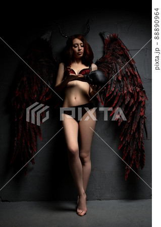 Sexy woman in provocative fallen angel concept with skull Sexy woman in provocative fallen angel concept with skull 88890964