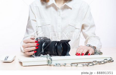 Copyright. The camera is chained to the photographer's hand. The concept of protecting the photographer from theft of his photos. Isolated on white background. 88891351