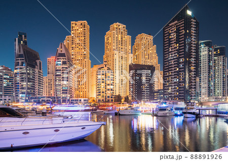 Jetty With Many Moored Yachts In Evening Night Illuminations. Night View Of Dubai Marina Towers 88891926