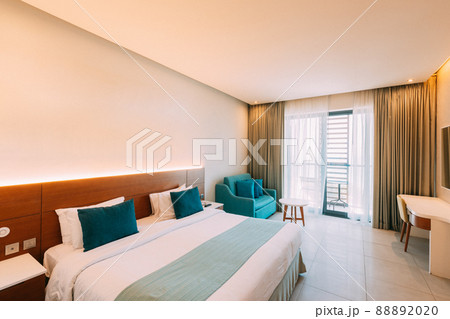 Hotel Room With Bed And Balcony With View On Sea. Home Interior With Bed, Sofa And Dressing Table 88892020