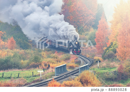 Retro steam train moves along the forest. 88893028