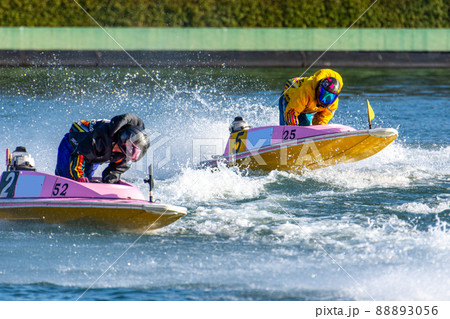 水しぶきを上げながらコーナーを曲がるボートレースの選手 88893056