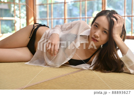 畳の上に横たわる黒いビキニの水着を着た若い女性 88893627