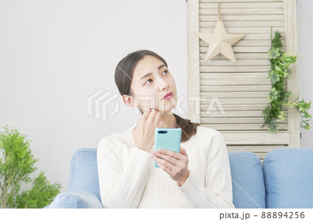 女性　スマホ　考える　リビング 88894256