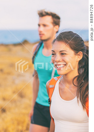 Happy young people walking on nature hike outdoors. Smiling Asian woman hiking hikers tourists with backpacks in summer travel Happy young people walking on nature hike outdoors. Smiling Asian woman hiking hikers tourists with backpacks in summer travel 88894726
