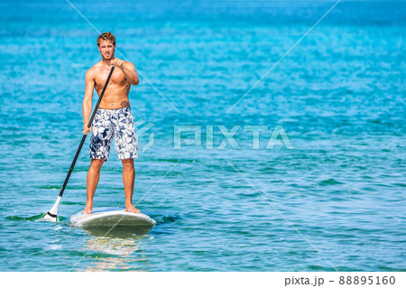 Paddle board stand up sup paddleboard man athlete paddling through blue ocean water background watersport activty on Hawaii beach. Active healthy lifestyle Paddle board stand up sup paddleboard man athlete paddling through blue ocean water background watersport activty on Hawaii beach. Active healthy lifestyle 88895160