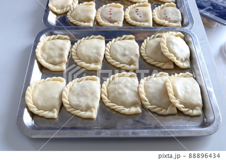 Raw curry puffs on a tray. 88896434