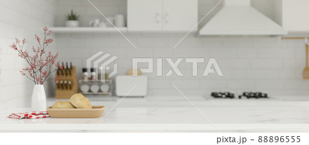 Copy space on white kitchen island over blurred kitchen interior background. Copy space on white kitchen island over blurred kitchen interior background. 88896555