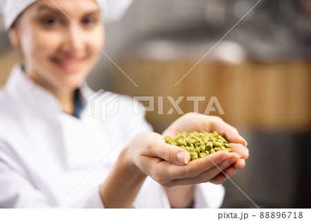 Woman brewer holding fresh hops in her hands on the territory of brewery 88896718