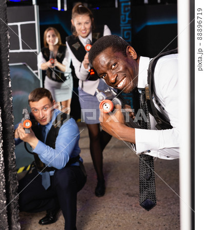 Group of colleagues holding laser pistols playing laser tag game 88896719
