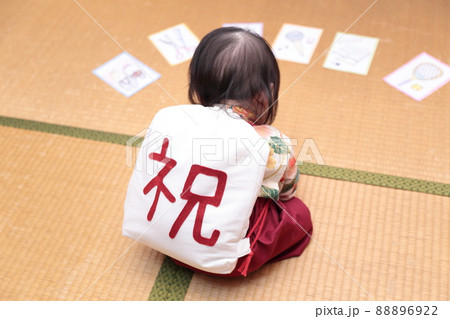 1歳の誕生日に袴を着て一升餅を背負って選び取りをする子供の写真素材