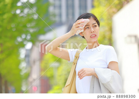 額をハンカチでぬぐう若い女性2 88898300