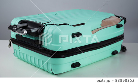 Broken plastic mint suitcase on a white background. Broken plastic mint suitcase on a white background. 88898352
