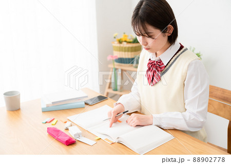 スマートフォンを観ながら勉強をする女子高生 スマートフォンを観ながら勉強をする女子高生 88902778