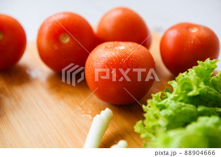 Fresh vegetables lie on a wooden cutting board 88904666