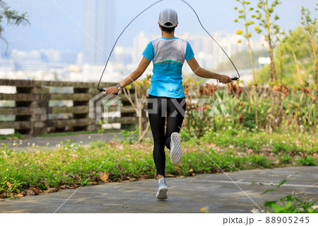 Asian woman skipping rope in park 88905245