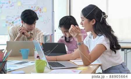 Young business team brainstorming and planning project strategy together at co working space. Young business team brainstorming and planning project strategy together at co working space. 88905664