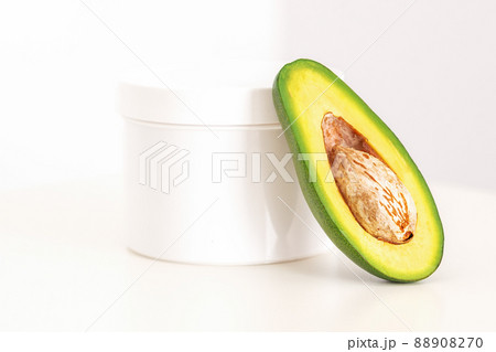 Skincare with natural cosmetics. White cosmetic jar of cream with half of the avocado near against white background, copy space, mockup Skincare with natural cosmetics. White cosmetic jar of cream with half of the avocado near against white background, copy space, mockup 88908270