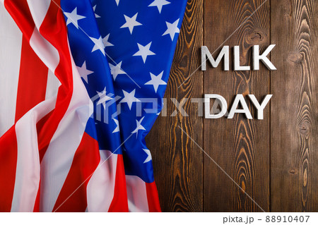 the word MLK day laid with silver metal letters on wooden surface with crumpled USA flag at left side the word MLK day laid with silver metal letters on wooden surface with crumpled USA flag at left side 88910407
