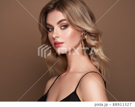 A beautiful young woman with shiny wavy blonde hair 88911327