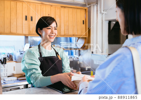 食事をテイクアウトする女性と渡す店員 88911865
