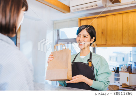 商品を渡す女性店員 88911866