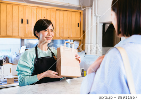 商品を渡す女性店員 88911867