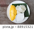 Sweet mango with sticky rice in the white plate topping with Jasmine flower, cuisine of Asia for summer  88915321