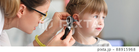 ENT doctor conducts physical examination of little girl ear 88915968