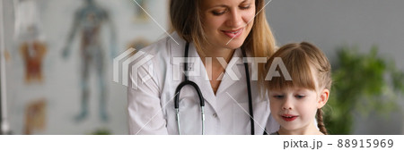 Woman pediatrician doctor communicates with girl shows card in medical office 88915969