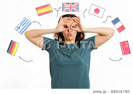 English Language Day. Portrait of a woman making a funny grimace on her face. White background with flags of different countries.The concept of choosing to study foreign languages 88916780