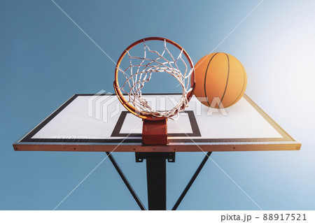Orange basketball ball falling into the hoop Orange basketball ball falling into the hoop 88917521