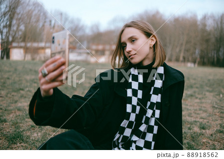 woman sitting in the park and using phone 88918562