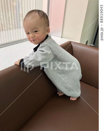 ショッピングモールのソファでつかまり立ちをして、満足そうな男の子。 88919045