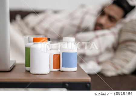 A sick man lying in bed and napping 88919494