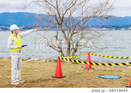 ドローンを操縦する作業員 88919694