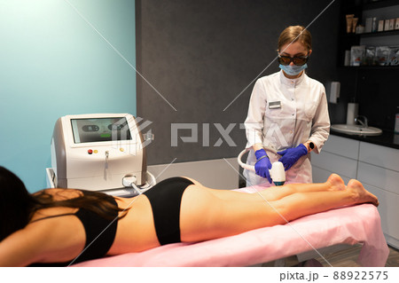 Girl lies on the couch when she is undergoing laser hair removal 88922575