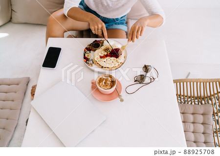 Crop unrecognizable woman enjoying breakfast Crop unrecognizable woman enjoying breakfast 88925708