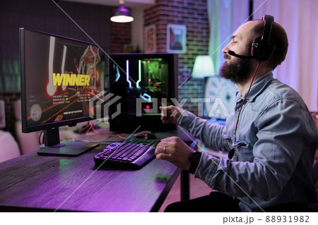 Male streamer enjoying video games win on online competition, playing action gaming championship. Young man winning rpg gameplay tournament on computer, live streaming on internet. Male streamer enjoying video games win on online competition, playing action gaming championship. Young man winning rpg gameplay tournament on computer, live streaming on internet. 88931982