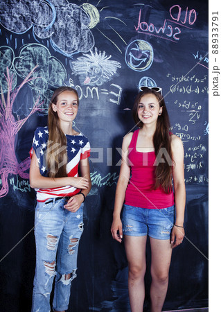 back to school after summer vacations, two teen girls in classroom with blackboard painted 88933791