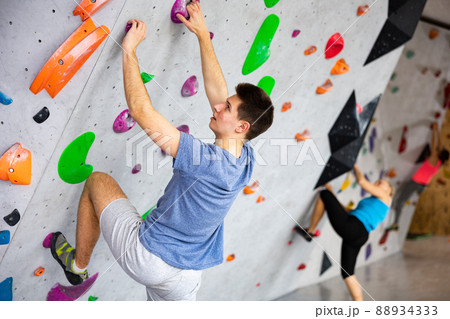 Young man exercising in climbing gym Young man exercising in climbing gym 88934333