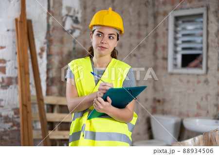 Woman taking notes on indoor construction site 88934506