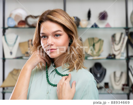 Girl trying on nephrite necklace Girl trying on nephrite necklace 88934669