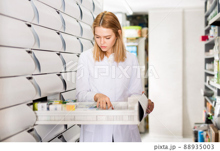 Female pharmacist offers medicine in a modern pharmacy 88935003